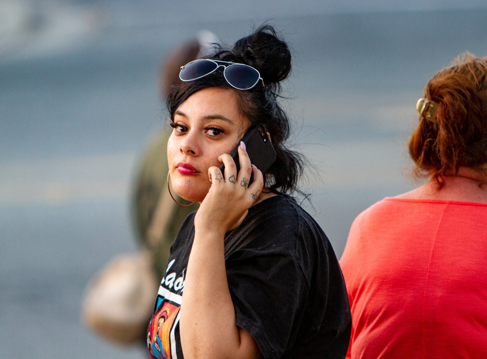 A woman is seen on her phone near the scene of a mass shooting during the Gilroy Garlic Festival in Gilroy, California, on Sunday. — Reuters