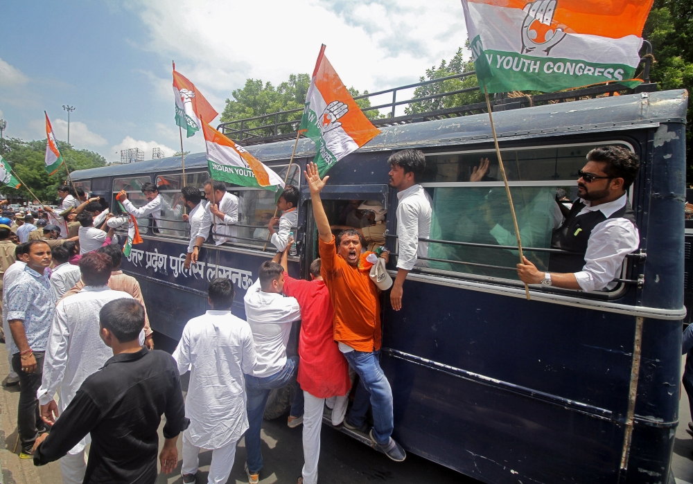 An activist from India's main opposition Congress party shouts slogans from a police bus during a protest demanding investigation in a highway collision in which a woman who is fighting a rape case against a legislator of the ruling Bharatiya Janata Party (BJP) was critically injured, in Lucknow, India, on Tuesday. — Reuters