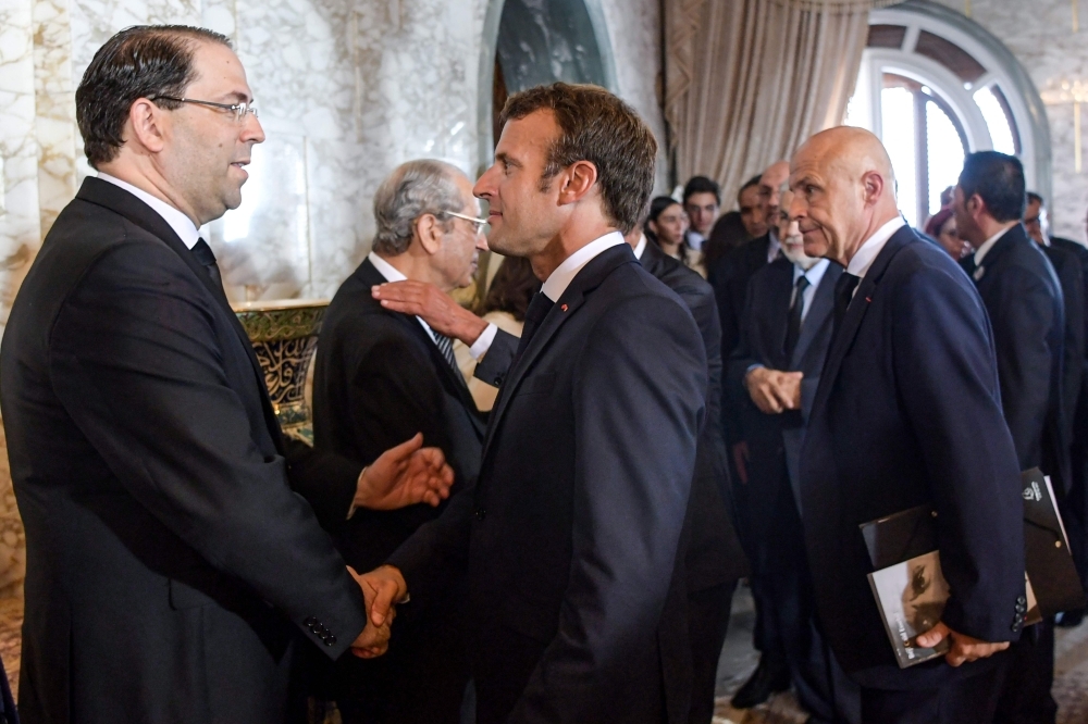 French President Emmanuel Macron, center, shakes hands with Tunisian Prime Minister Youssef Chahed, left, during the state funeral of late Tunisian President Beji Caid Essebsi at the presidential palace in the capital's eastern suburb of Carthage in this July 27, 2019 file photo.  — AFP