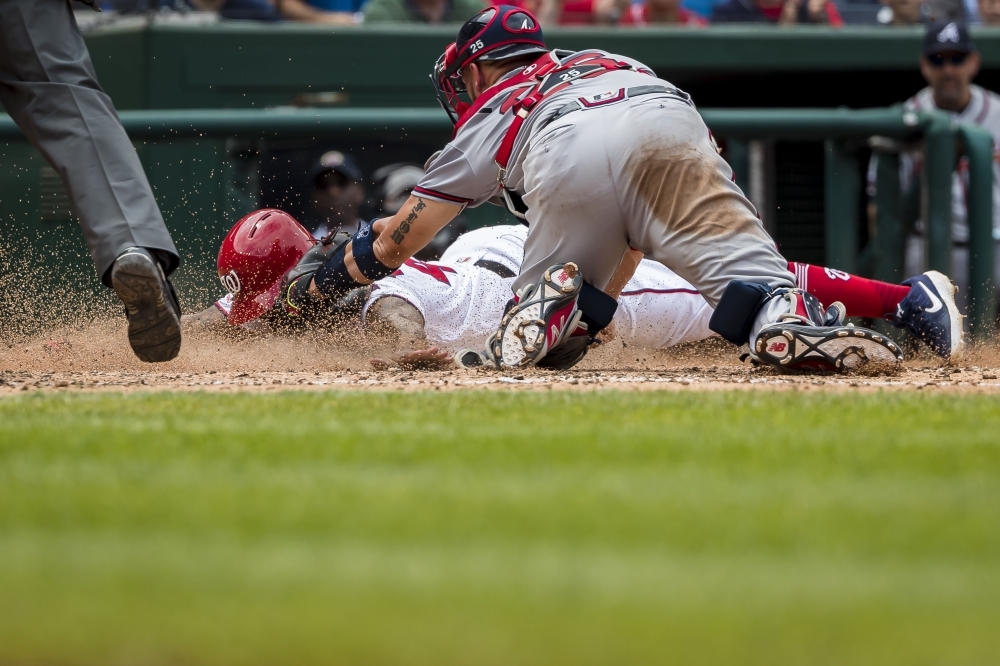 Howie Kendrick of the Washington Nationals is tagged out at home plate by Tyler Flowers of the Atlanta Braves during the sixth inning at Nationals Park in Washington, DC, on Wednesday. — AFP