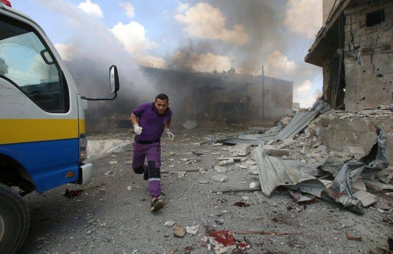 A rescuer from the Violet NGO runs during airstrikes by Syrian regime forces in Maar Shurin on the outskirts of Maarat Al-Numan in northwest Syria in this July 16, 2019 file photo. — AFP