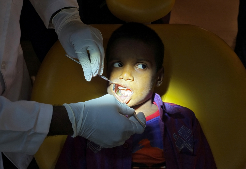 A doctor examines the teeth of a 7-year-old boy inside a hospital in Chennai, India, on Friday. — Reuters