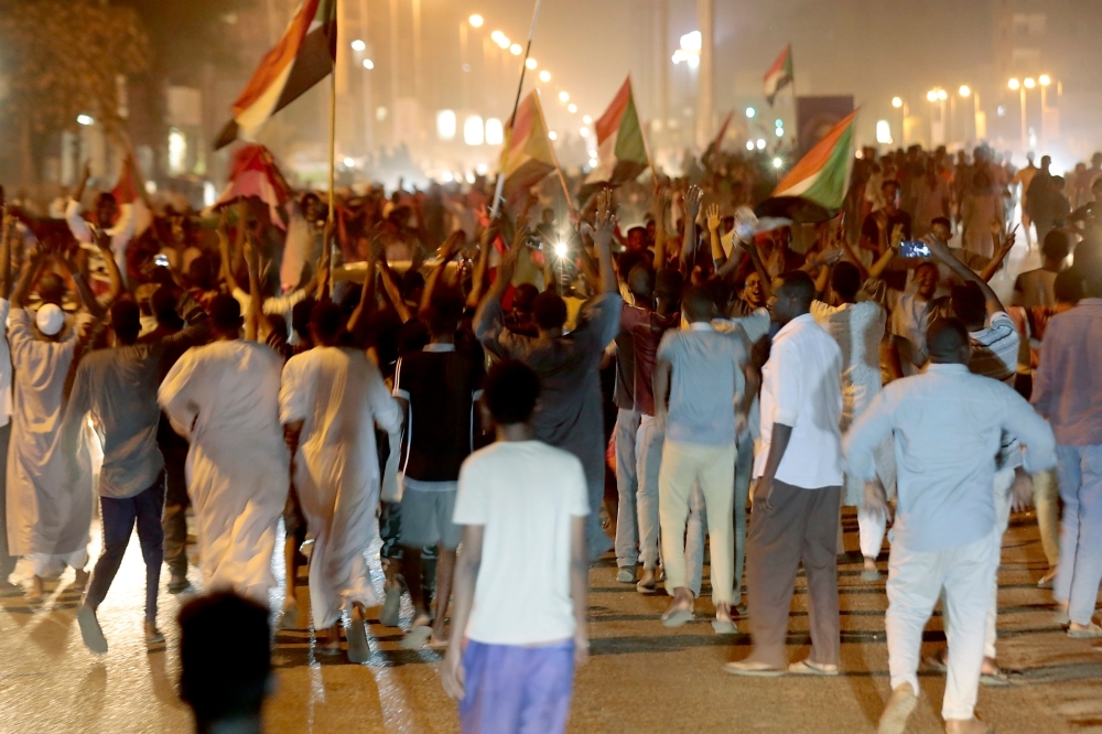 Sudanese celebrate in Khartoum early Saturday, after the ruling generals and protest leaders reached a 