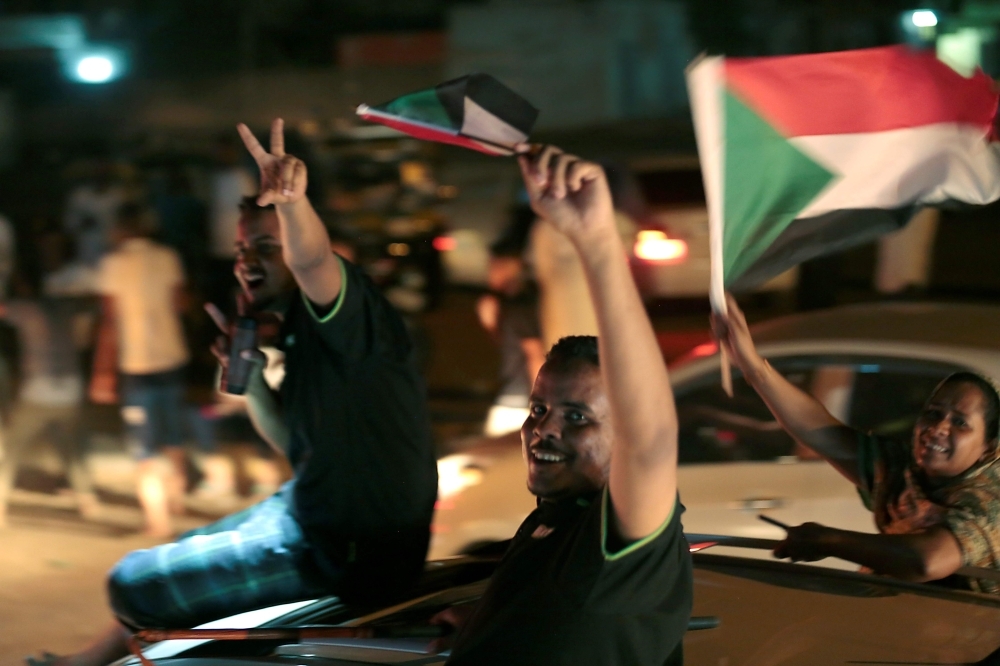 Sudanese celebrate in Khartoum early Saturday, after the ruling generals and protest leaders reached a 