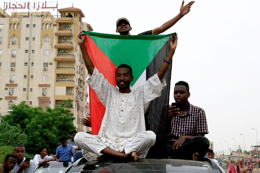 Sudanese celebrate in Khartoum early Saturday, after the ruling generals and protest leaders reached a 