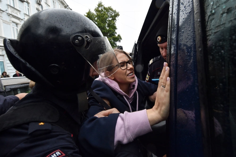  Police officers detain opposition politician, would-be candidate Lyubov Sobol on her way to an unsanctioned rally urging fair elections in downtown Moscow on Saturday. -Courtesy photo