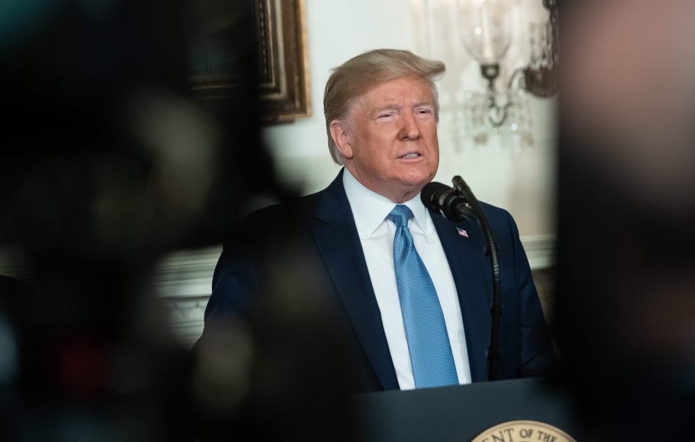 US President Donald Trump speaks about the mass shootings from the Diplomatic Reception Room of the White House in Washington on Monday. — AFP