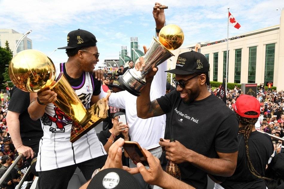 Kyle Lowry and Kawhi Leonard of the Toronto Raptors hold the Championship Trophy on the team bus during the Toronto Raptors Championship Victory Parade in Toronto, Ontario, in this June 17, 2019 file photo. — AFP