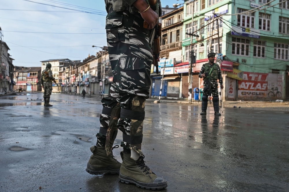 Indian security personnel stand guard on a street during a curfew in Srinagar on Thursday. — AFP