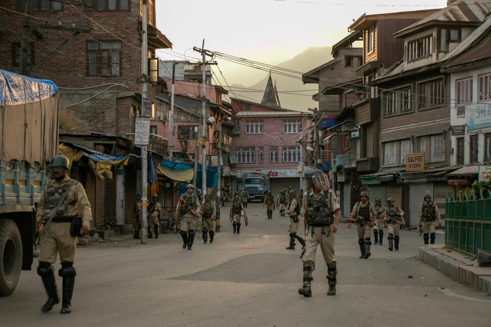 Indian security personnel walk on a street in Srinagar on Friday, as widespread restrictions on movement and a telecommunications blackout remained in place after the Indian government stripped Jammu and Kashmir of its autonomy. — AFP