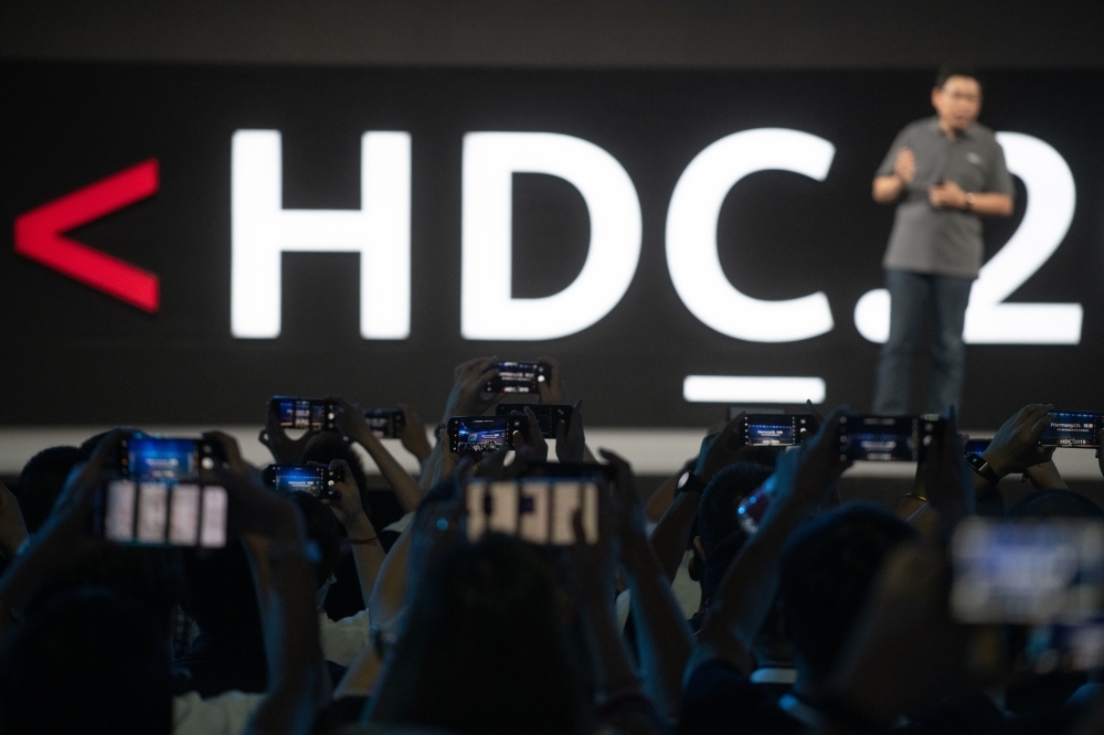 Journalists take pictures as Richard Yu, head of Huawei's consumer business, unveils the company's new HarmonyOS operating system during a press conference in Dongguan, Guangdong province, on Friday. — AFP