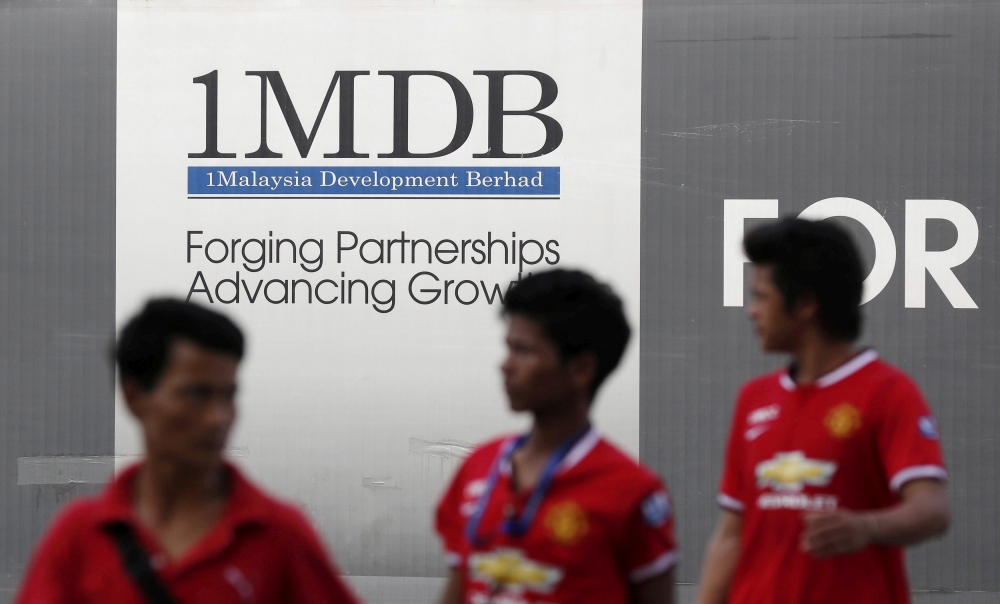 Men walk past a 1Malaysia Development Berhad (1MDB) billboard at the fund's flagship Tun Razak Exchange development in Kuala Lumpur in this March 1, 2015 file photo. — Reuters