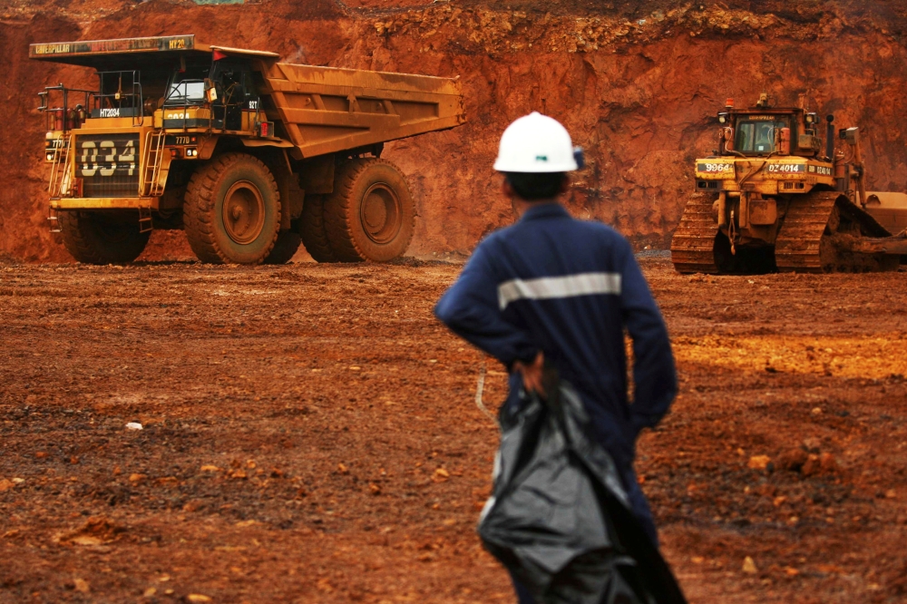 A worker watches as trucks load raw nickel near Sorowako, on Indonesia's Sulawesi island, in this Jan. 8, 2014 file photo. — Reuters