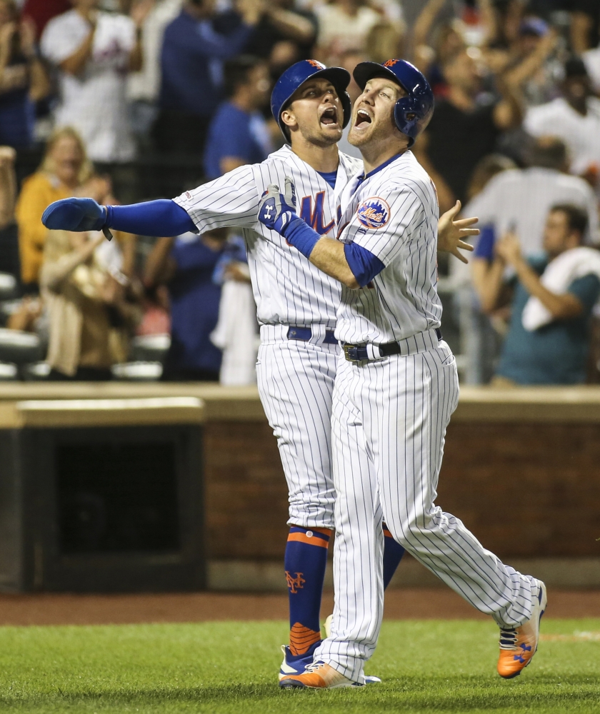 New York Mets third baseman Todd Frazier, (21) celebrates with left fielder J.D. Davis (28) after hitting a three run home run in the bottom of the ninth inning against the Washington Nationals at Citi Field in New York on Friday. — Reuters