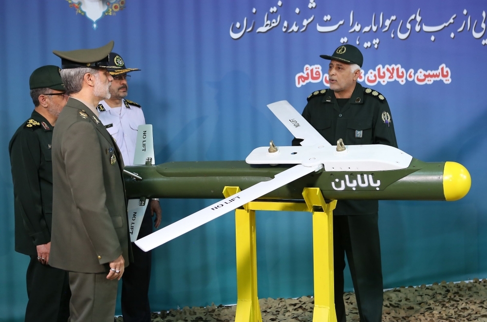 A handout picture released by Iran's Defense Ministry on Aug. 6, 2019 shows Defense Minister Brigadier General Amir Hatami, left front, standing by the missile 