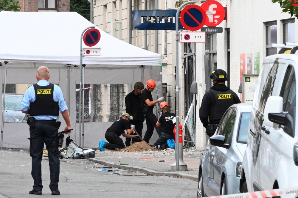 Danish police technicians work inspect the scene on Hermodsgade outside a local police station in Copenhagen on Saturday, after the police station was hit by an explosion in the early morning. — AFP