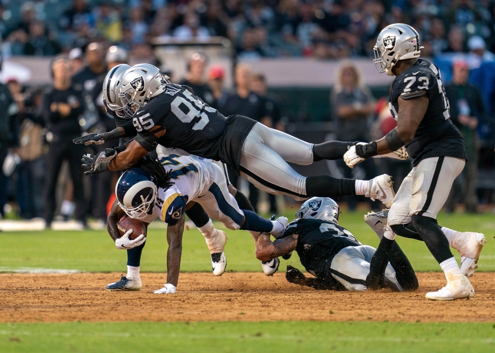Los Angeles Rams wide receiver Nsimba Webster (14) is tacked by Oakland Raiders defensive end Quinton Bell (95) and Oakland Raiders defensive back Dallin Leavitt (32) during the fourth quarter at Oakland Coliseum in Oakland, California, on Saturday. — AFP