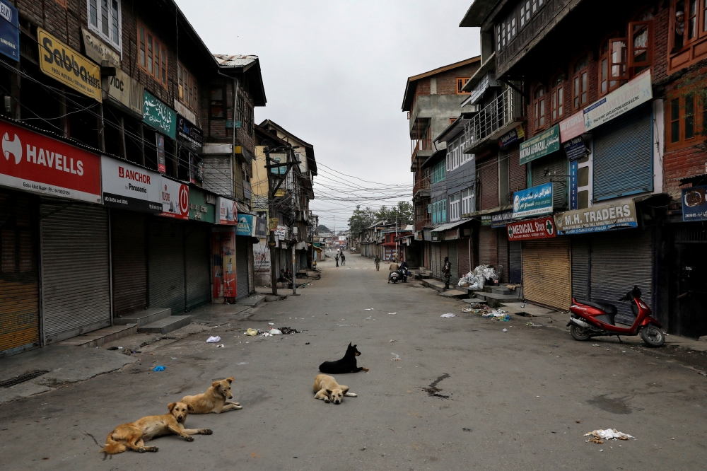 Dogs rest on an empty street during restrictions after the scrapping of the special constitutional status for Kashmir by the government, in Srinagar, India, on Sunday. — Reuters