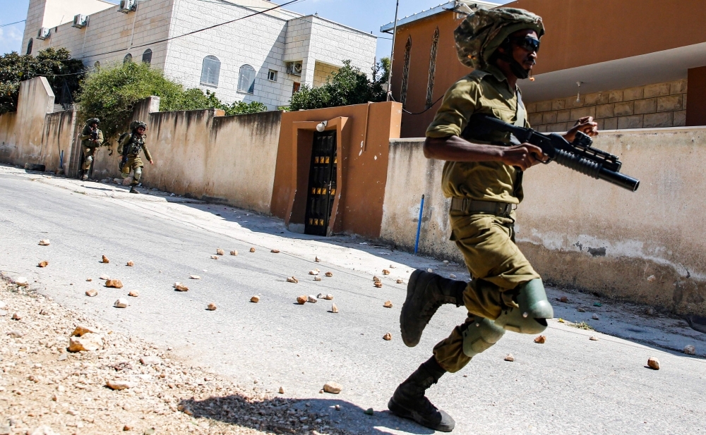 An Israeli soldier runs during clashes with Palestinian protesters following a weekly protest against the expropriation of Palestinian land by Israel in the village of Kfar Qaddum near the Jewish settlement of Qadumim (Kedumim), in the Israeli-occupied West Bank, in this Aug. 9, 2019 file photo. — AFP