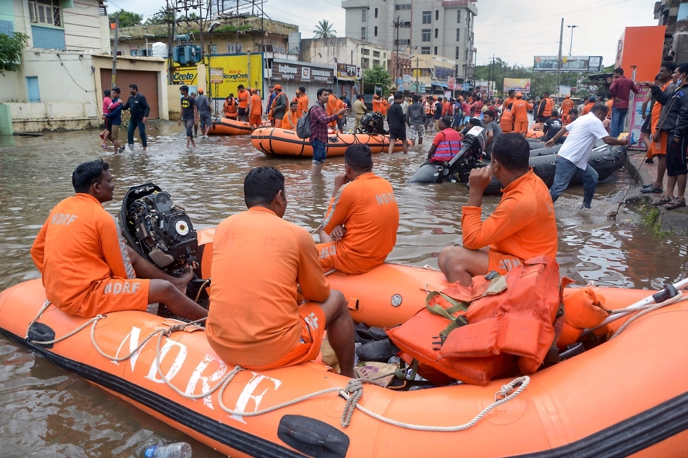 National Disaster Response Force (NDRF) rescue team check for the flood situation, as floodwaters have receded, at Sangli, Maharashtra, on Sunday. — AFP