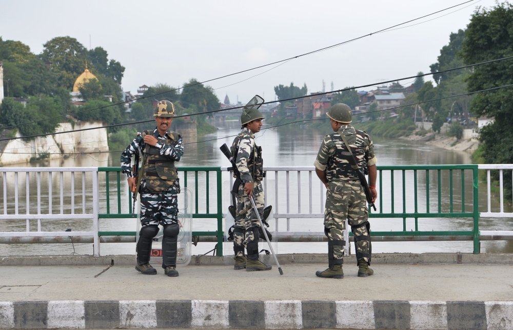 Security personnel stand guard on a street during a lockdown in Srinagar on Sunday. — AFP