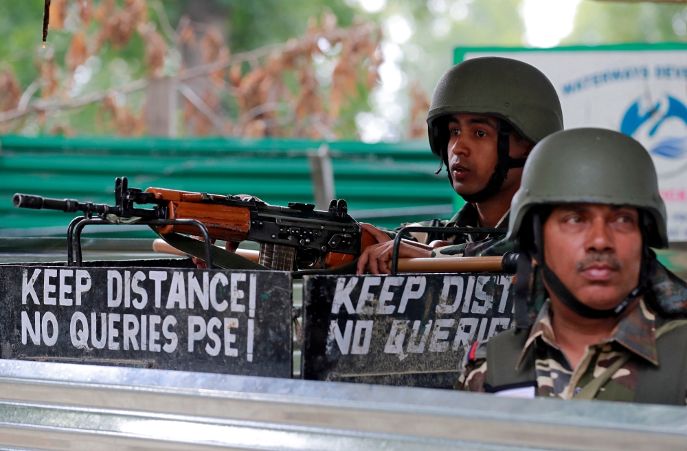 Indian security force personnel keep guard alongside a road during restrictions after the government scrapped the special constitutional status for Kashmir in Srinagar on Thursday. — Reuters