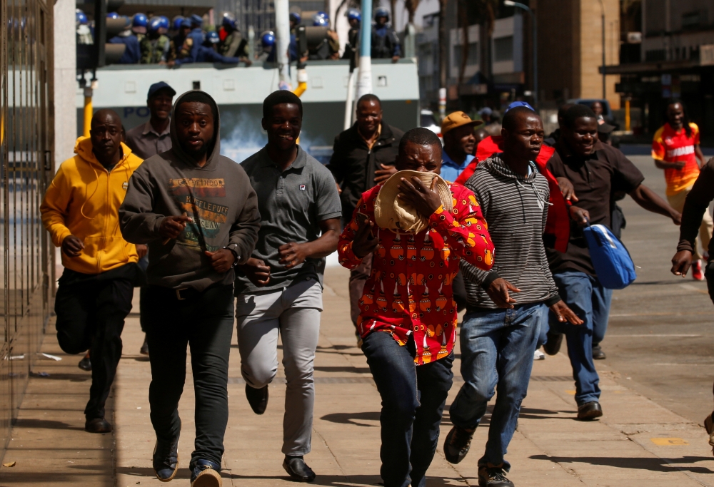 Protesters flee from teargas during clashes after police banned planned protests over austerity and rising living costs called by the opposition Movement for Democratic Change (MDC) party in Harare, Zimbabwe, on Friday. -Reuters 
