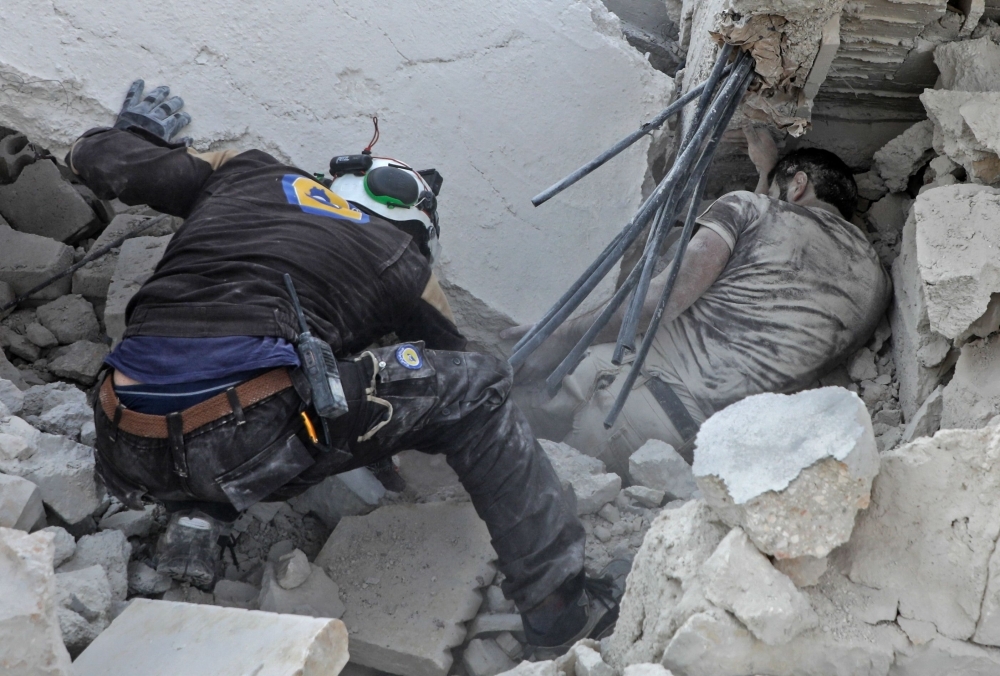 A member of the Syrian Civil Defense (White Helmets) recovers a body from the rubble after a reported airstrike by regime planes on the town of Maaret Hurmah in the southern countryside of Syria's northwestern Idlib province in this  Aug. 14, 2019 file photo. — AFP