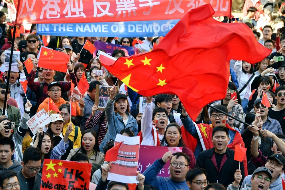 Pro-China activists march on the streets of Sydney on Saturday, as they rally against ongoing protests in Hong Kong. -AFP