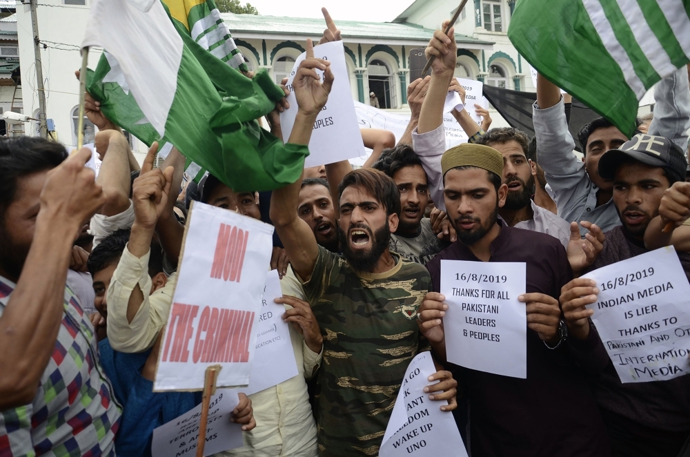 Kashmiri pedestrians walk past a security personnel vehicle in Srinagar on Saturday. Seventeen out of around 100 telephone exchanges were restored in the restive Kashmir Valley, the local police chief told AFP, after an almost two-week communications blackout. — AFP