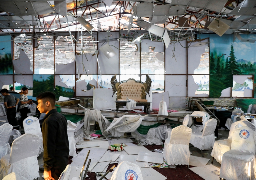 On Sunday, workers inspect a wedding hall after a blast in Kabul, Afghanistan on Saturday. -Reuters