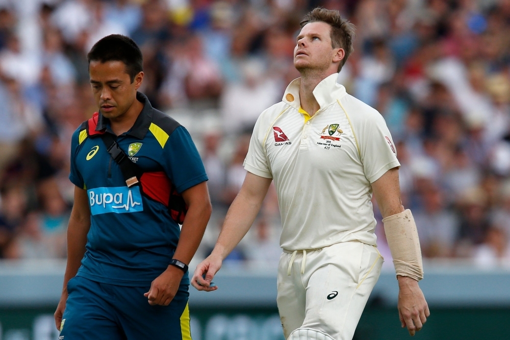 Australia's Steve Smith (R) walks off of the pitch after being hit in the head by a ball off the bowling of England's Jofra Archer (unseen) during play on the fourth day of the second Ashes cricket Test match between England and Australia at Lord's Cricket Ground in London, on Saturday. — AFP