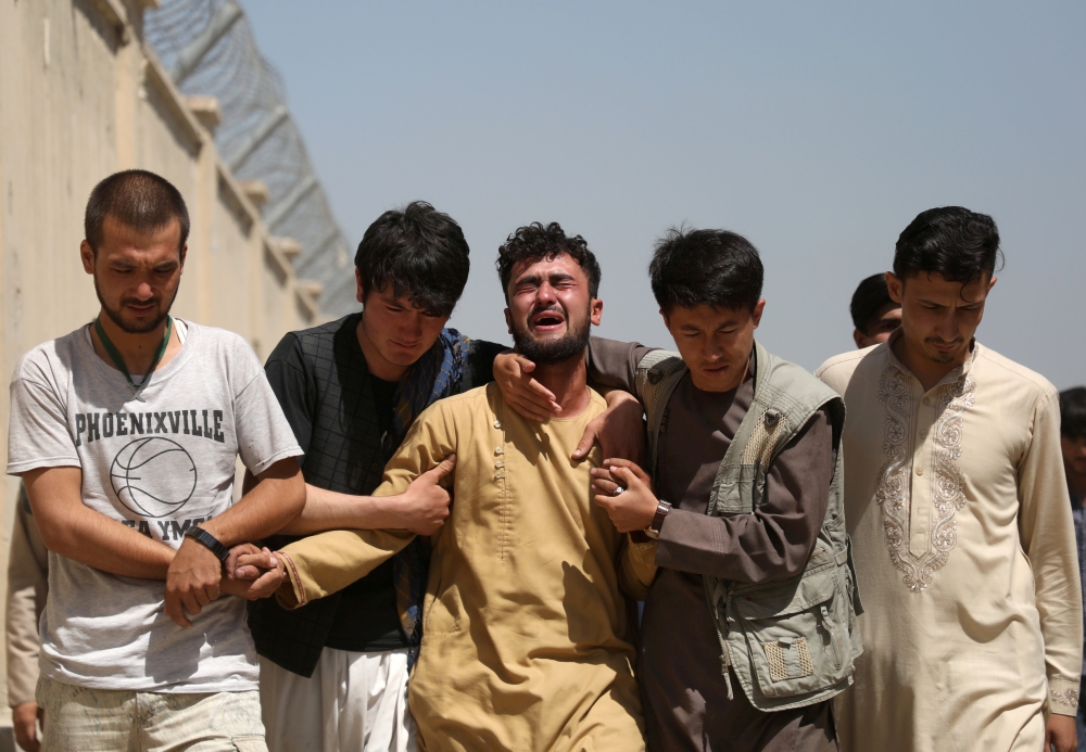 An Afghan mourns during the funeral of his brother. — Reuters