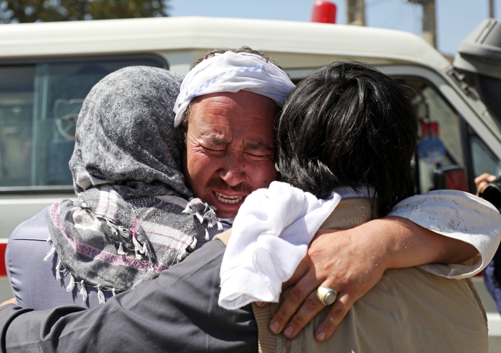 An Afghan mourns during the funeral of his brother. — Reuters