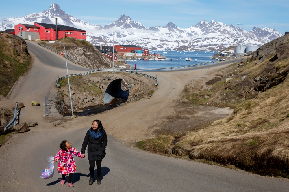  A woman and child hold hands as they walk on the street in the town of Tasiilaq, Greenland, June 15, 2018. -Reuters