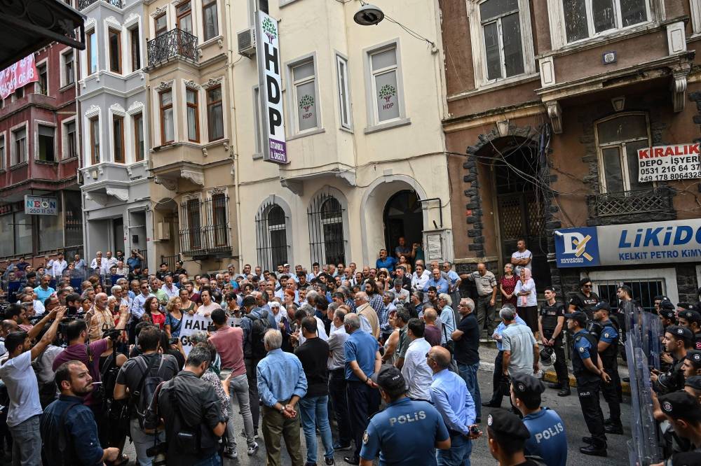 Protesters gather for demonstration in front of the People's Democracy Party (HDP) headquarter, in Istanbul, on Monday as they are surrounded by Turkish anti-riot police forces. — AFP