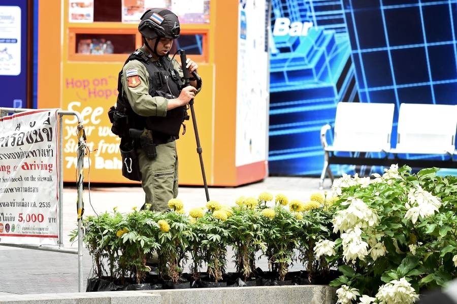 A policeman from the explosive ordinance disposal unit runs a bomb detector through a bed of flowers at the scene of an explosion in Bangkok on August 2, 2019. -Courtesy photo