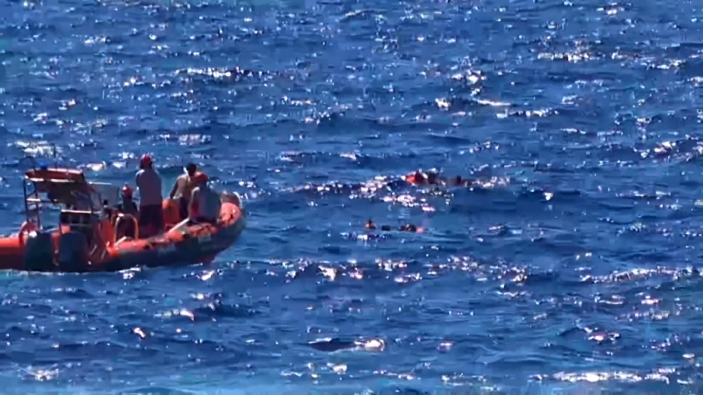 This grab from a video taken by Local Team shows migrants rescued for days by NGO Proactiva Open Arms charity ship, being rescued by a Spanish patrol boat after throwing themselves in the water to try and swim to the nearby Italian island of Lampedusa in a desperate move after days stuck on board, on Tuesday. — AFP