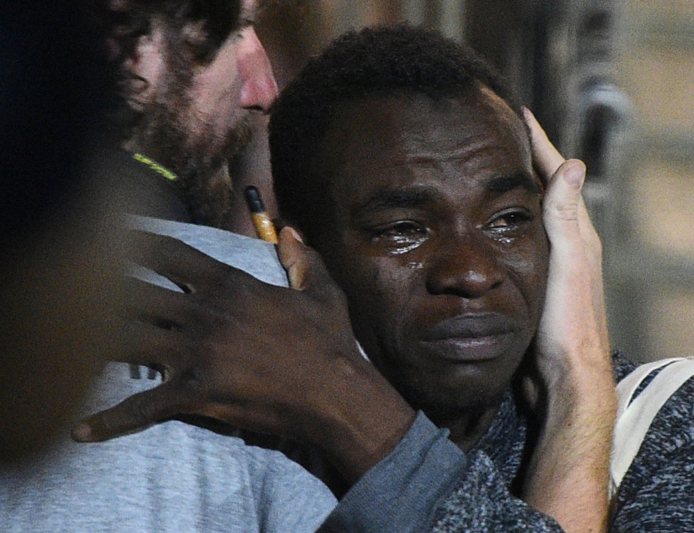 A migrant reacts as he disembarks the Spanish rescue ship Open Arms NGO, after it arrived in Lampedusa, Italy, on Tuesday. — Reuters 