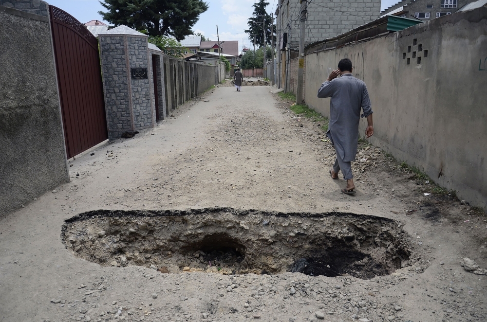 This photo taken on Aug.16, 2019 shows a man walking on a back street with a hole dug in the ground to restrict movements in the Soura locality in Srinagar, during a lockdown imposed by Indian authorities after stripping Kashmir of its autonomy. — AFP