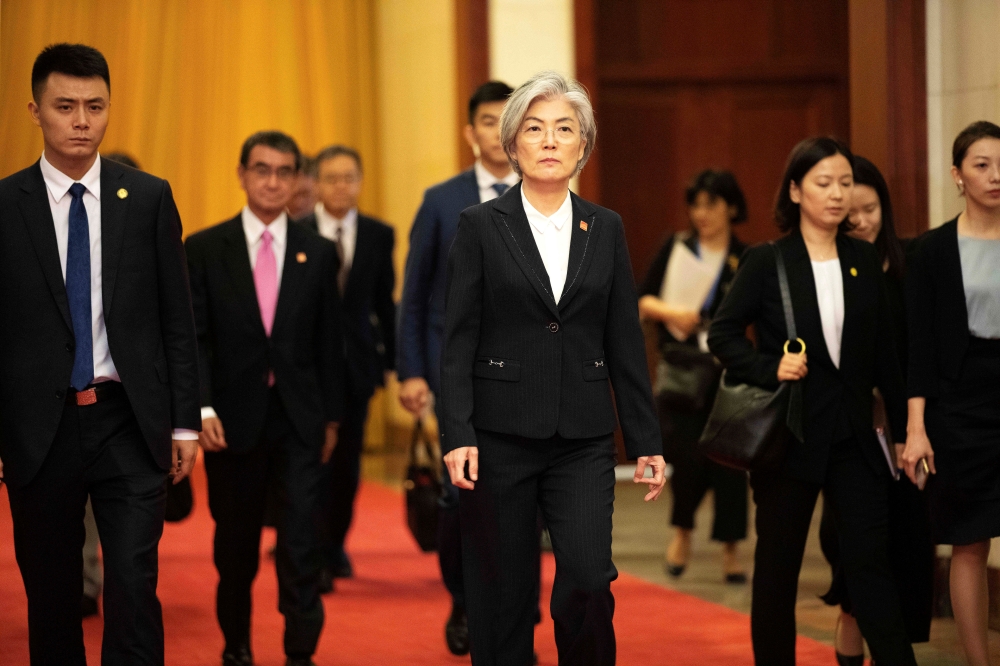 South Korean Foreign Minister Kang Kyung-wha, center, and Japanese Foreign Minister Taro Kono, second left, arrive for their meeting with Chinese Premier Li Keqiang at the Great Hall of the People (GHOP) in Beijing, China, on Thursday. — Reuters