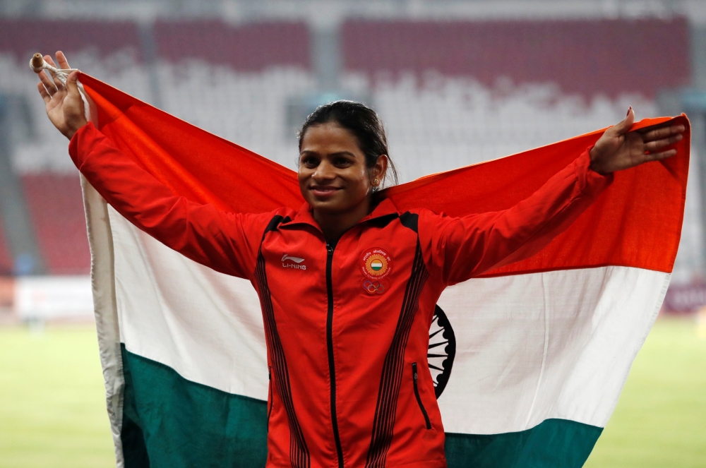 Silver medalist Dutee Chand of India poses with her national flag during the Asian Games women's 100m final medal ceremony at GBK Main Stadium,Jakarta, Indonesia in this Aug. 26, 2018 file photo. — Reuters
