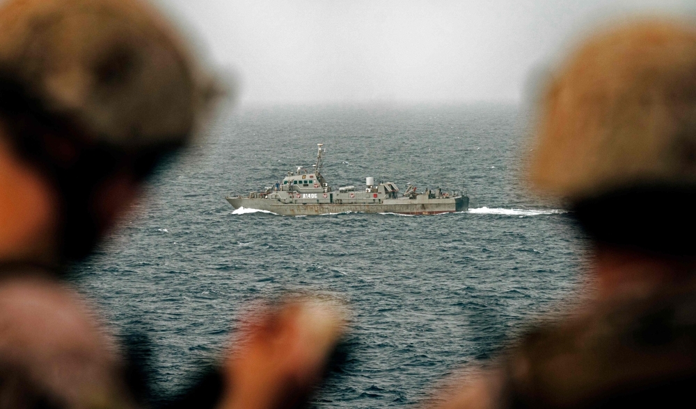 This handout picture taken by the US Navy on Aug. 12, 2019, shows US sailors aboard an amphibious transport dock ship as they keep watch on Iranian fast attack craft in the Strait of Hormuz.  — AFP