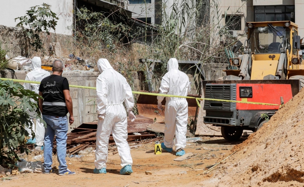 Forensic investigators of Lebanon's military intelligence inspecting the scene where two drones came down in the vicinity of a media center of the Shiite Hezbollah movement in Beirut, Sunday. — AFP 