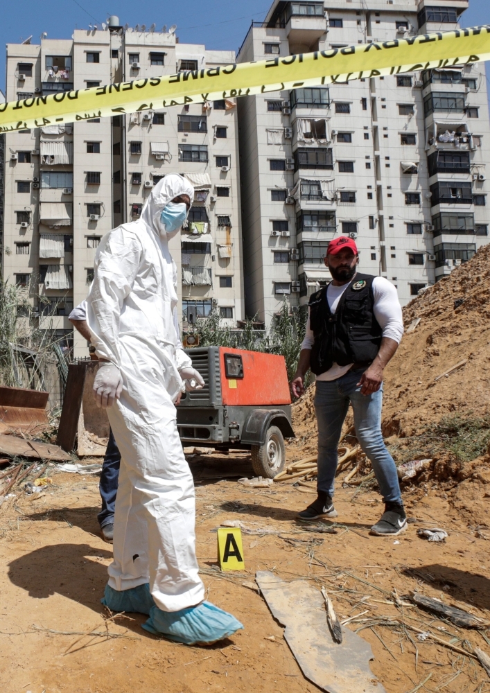 Forensic investigators of Lebanon's military intelligence inspecting the scene where two drones came down in the vicinity of a media center of the Shiite Hezbollah movement in Beirut, Sunday. — AFP 