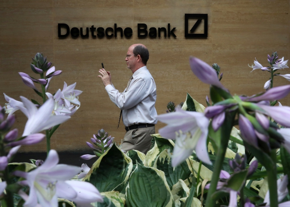 A man walks past a Deutsche Bank office in London,  July 8, 2019. -Reuters