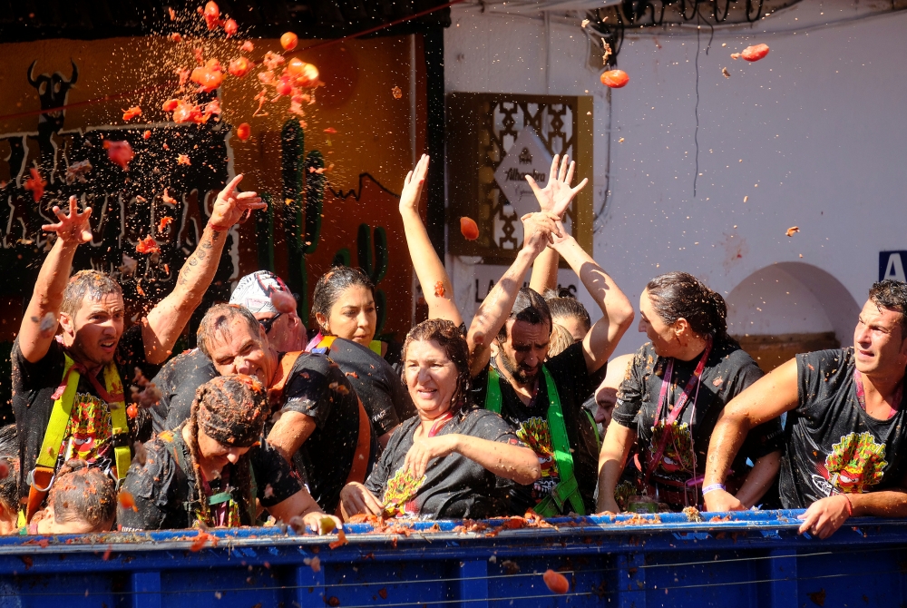 Revelers on a truck throw tomatoes into the crowd during the annual 
