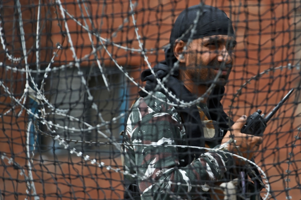 A security personnel stands guard on a street in Srinagar, India, on Wednesday. — AFP