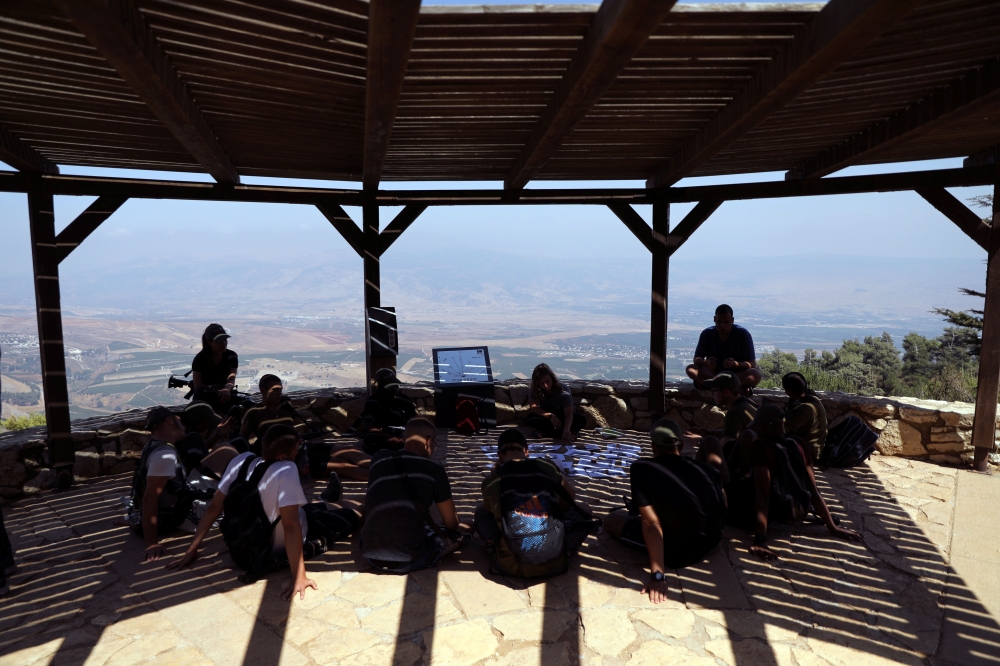 Israeli soldiers sit beneath a shade at an observation point overlooking Lebanon, near Kibbutz Misgav Am, in northern Israel, close to the border with Lebanon, on Wednesday. — Reuters