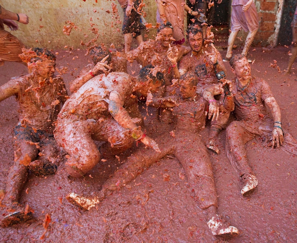 Revelers covered in tomato pulp take part in  the annual 